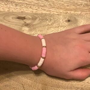 It is a kids and adult bracelet about 6 inches and it is pink, white and gold